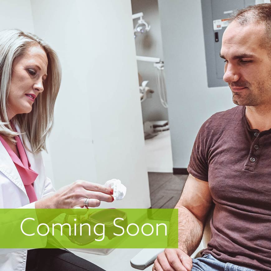 Photo of patient talking to dentist while receiving mouthpiece for sleep apnea